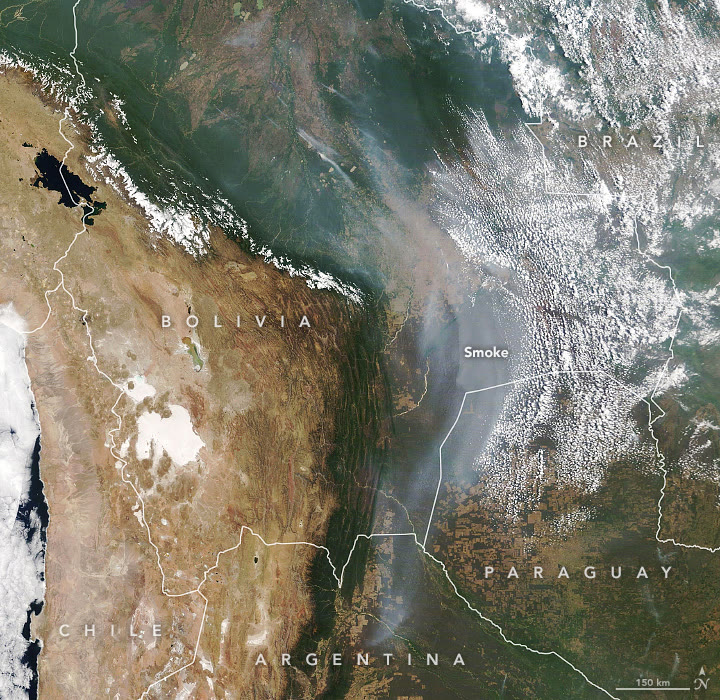 Satellite view of Bolivia and neighboring countries with a long gray plume of smoke stretching southeast across the lowlands toward Paraguay.